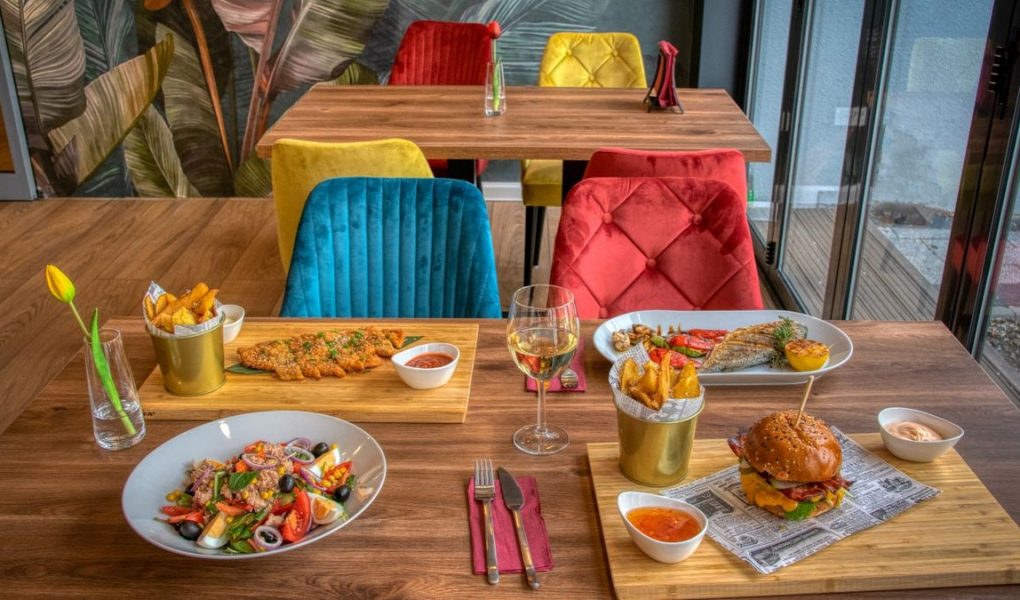 Colorful dining setup in a modern restaurant featuring diverse meals and vivid decor.