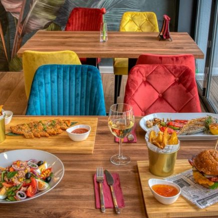 Colorful dining setup in a modern restaurant featuring diverse meals and vivid decor.