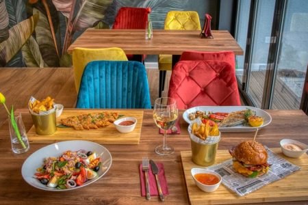 Colorful dining setup in a modern restaurant featuring diverse meals and vivid decor.
